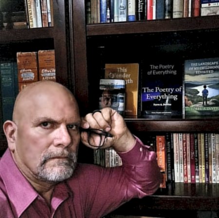 Torre in front of shelf of his books